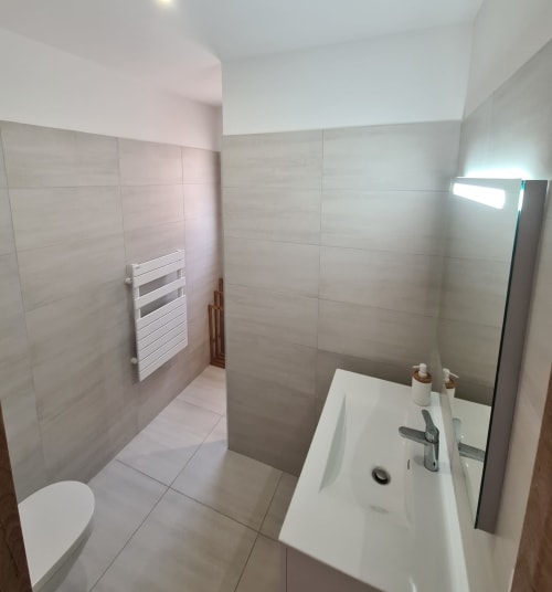 Modern bathroom at Villa Corsica, featuring a white sink, an Italian-style walk‑in shower, an electric towel warmer and tiled finishes, managed by the Corsu di Core concierge service.