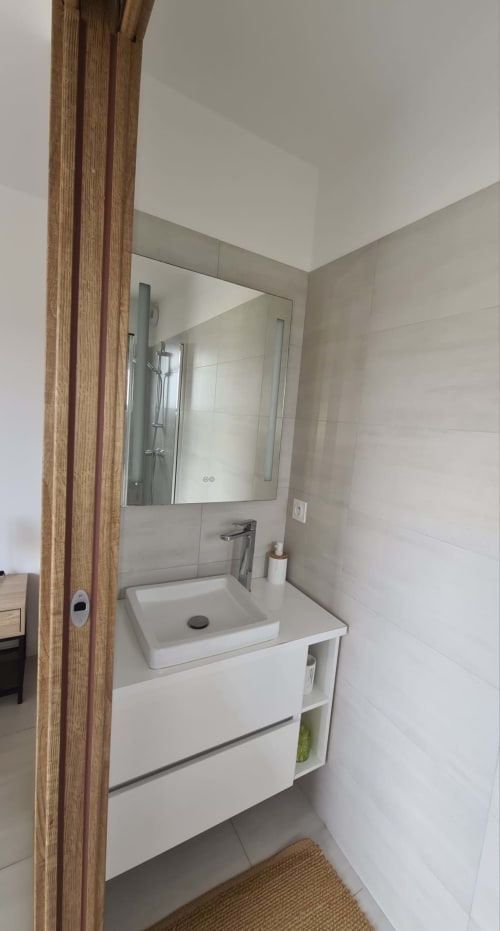 Modern bathroom with a white basin, built‑in sink and mirror at Villa Corsica, managed by the Corsu di Core concierge service.