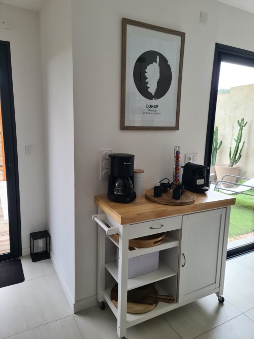 Kitchen corner of Villa Corsica in Favone, featuring a coffee maker and household appliances on a wooden countertop, managed by the Corsu di Core concierge service.