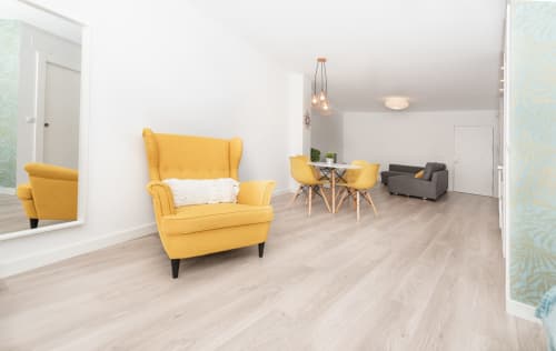 Bright yellow loft living room at Sur Suites Málaga with modern furniture and wooden floors