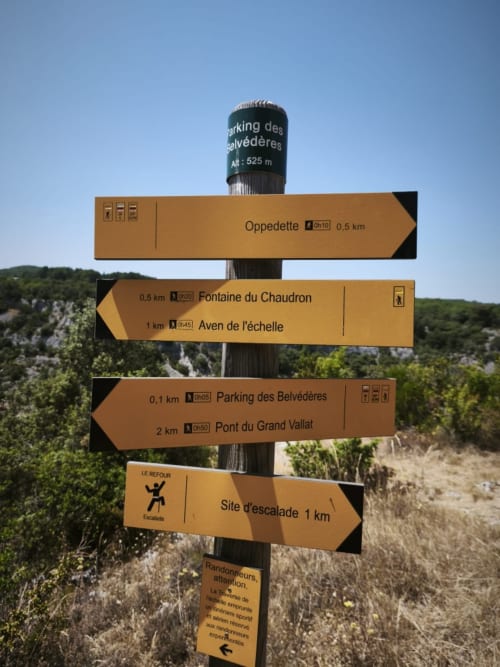 Panneaux directionnels de randonnée à Barret-sur-Méouge indiquant l'Oppidum, la Fontaine du Chaudron et les sites d'escalade à proximité.