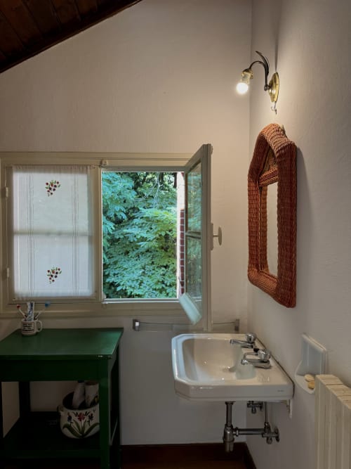 Bagno della villa Sally's Case Vacanze a Sanremo con lavabo, finestra sulla veranda e portasciugamani in vimini