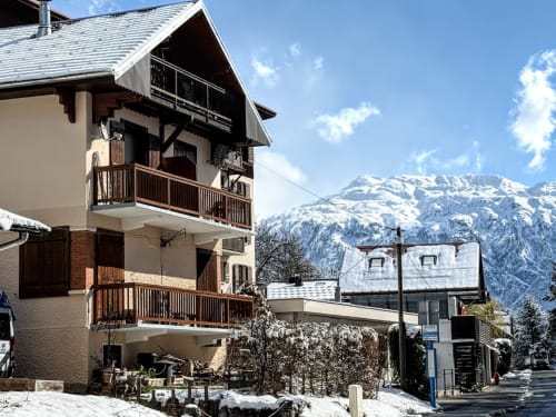 Façade de l'hôtel Fizhome Mt Blanc à Passy avec pics alpins enneigés et balcons en bois