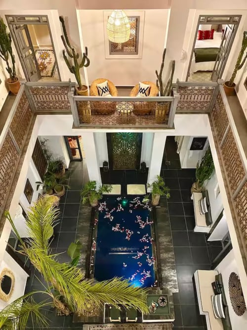 Vue aérienne de la cour du riad 191 à Marrakech avec piscine, balcons, plantes et portes