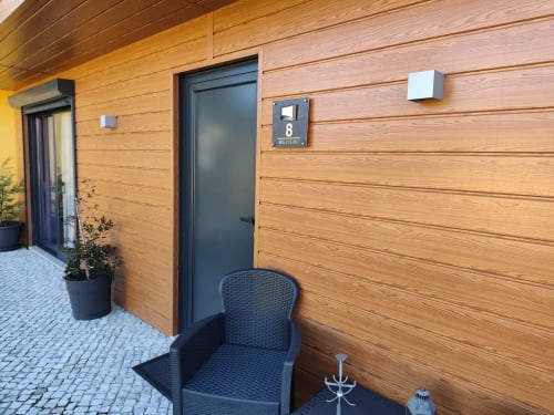 Exterior do Bungalow Deluxe no hotel Quinta Salinas, Aveiro, Portugal com fachada de madeira e vista da piscina na entrada