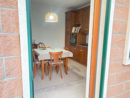 Appartamento Iris a Le case di Clara con tavolo da pranzo, sedie in legno, cucina e lampada a sospensione