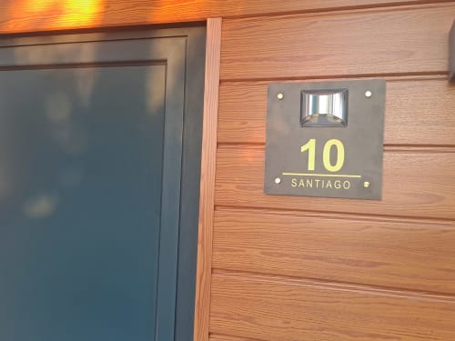 Placa do número do quarto Bungalow Santiago no hotel Quinta Salinas em Aveiro, Portugal com exterior de madeira e iluminado