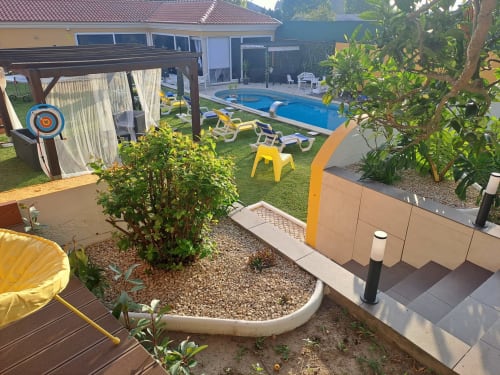 Jardim da Quinta Salinas com piscina, espreguiçadeiras amarelas e pátio ajardinado em Aveiro