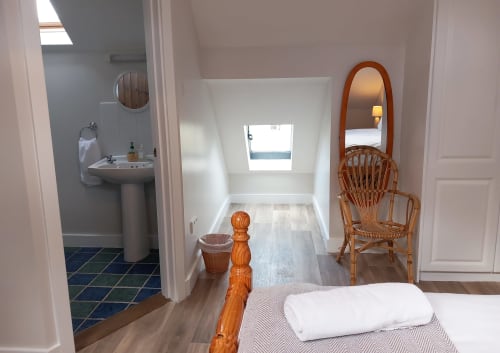 Cottage bedroom at Leitrim Quay with wooden furnishings, en suite bathroom, and skylight overlooking lake views in Leitrim.