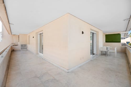 Spacious 2-bedroom apartment terrace in Marbella with modern seating area and green wall accents