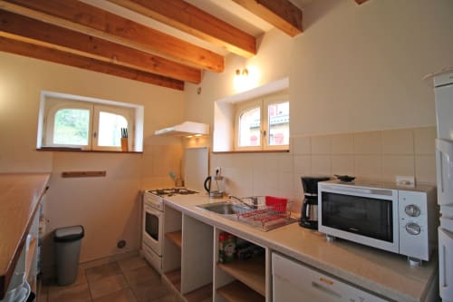 Rustic kitchen in Gîte Le Bûcher cottage at Domaine de Bort near Limoges with wooden beams and modern appliances