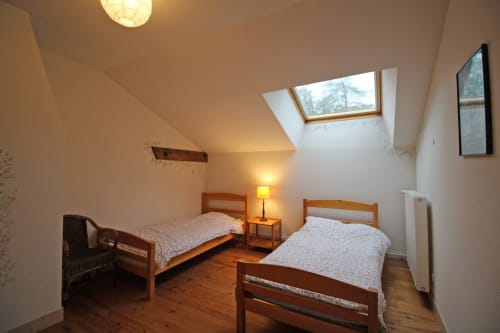 Twin bedroom in Le Bûcher cottage at Domaine de Bort near Limoges, with wooden beds and skylight