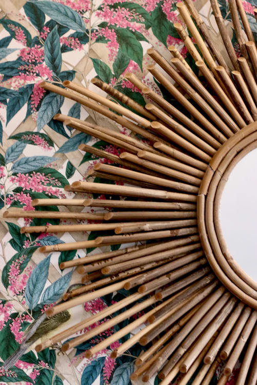 Woven rattan fan against floral botanical wallpaper at Domaine de Bort near Limoges, France