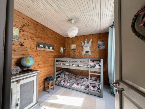 Chambre douillette en bois avec lits superposés, globe, cheminée et plafond blanc au Domaine le Manoir, Fossemagne