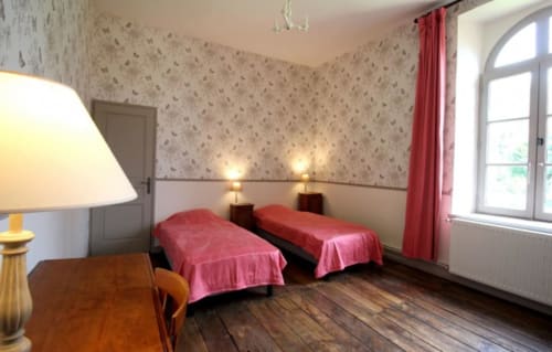 Twin bedroom with red bedspreads in Gîte de L'Orangerie at Domaine de Bort near Limoges, France