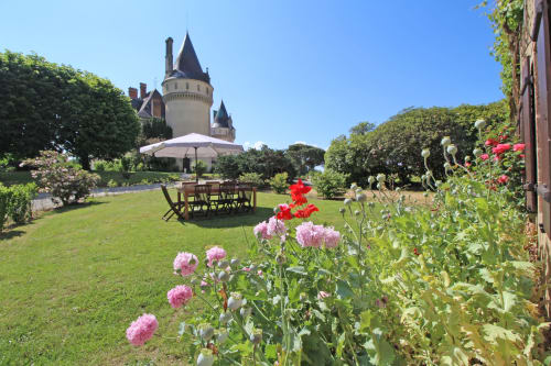 Castle with gardens at Domaine de Bort near Limoges, featuring pink flowers and lawn seating area