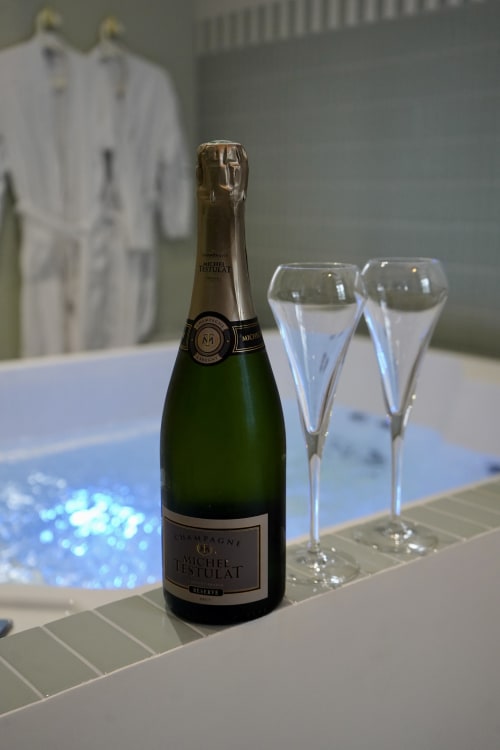 Bouteille de Champagne Michel Dousset avec deux flûtes à La Maison D'olivier, boutique hôtel à Mesnard La Barotière, France