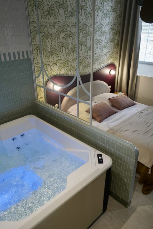 Chambre de luxe à La Maison D'olivier avec baignoire balnéo illuminée et chambre avec paravent décoratif à Mesnard La Barotière