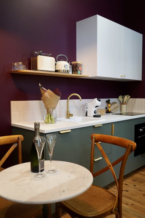 Cuisine contemporaine à La Maison D'olivier avec mobilier teal, table en marbre et mur d'accent bordeaux à Mesnard la Barotière