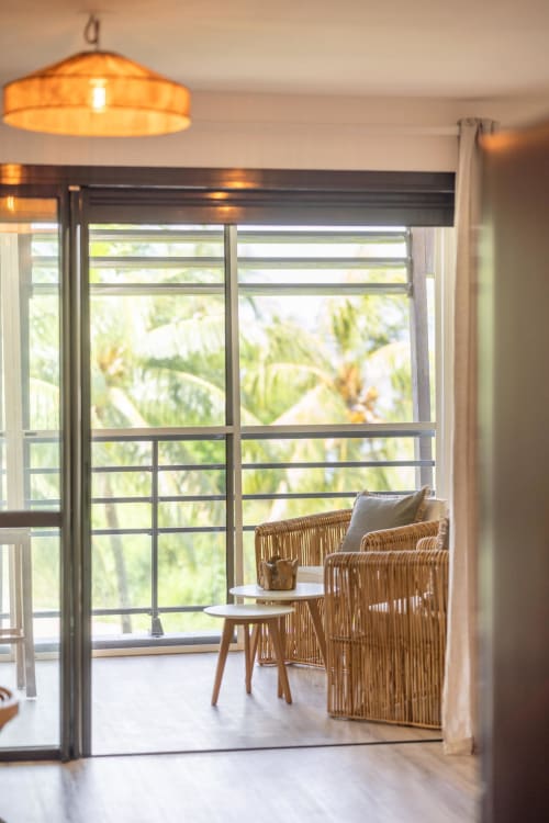 Vista Del Mar balcony with wicker seating, tropical views, and modern sliding doors in Sainte-Anne