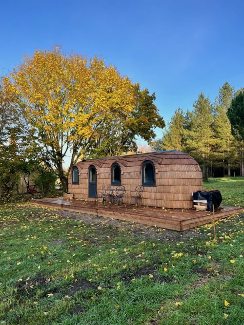 Petite maison en tonneau avec toit voûté à la Cour Du Liège à Baugé-en-Anjou, entourée de jardins automnaux et d'arbres