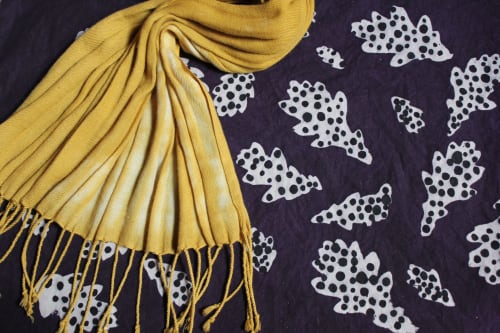 Yellow fringed scarf on navy fabric with white spotted leaf patterns at La Cachette d'Oona, Saint-Jean-de-Monts