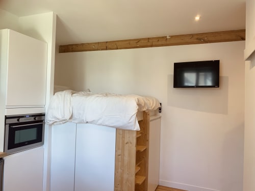 Studio La Belle Odet à Quimper : lit mezzanine, literie blanche, kitchenette et TV murale