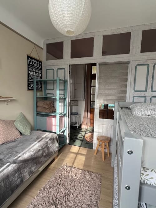 Chambre lumineuse du Domaine le Manoir avec lits jumeaux, étagères turquoise, parquet et décoration moderne