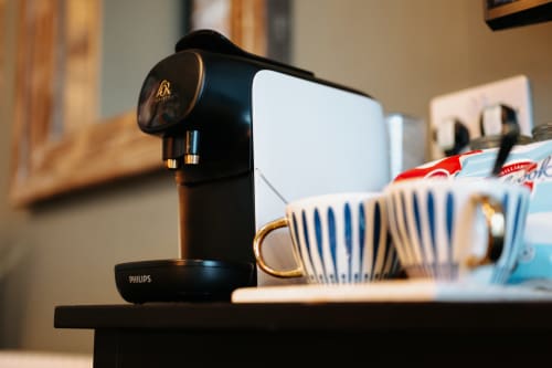 Philips coffee machine with striped mug in Shrewsbury Rooms deluxe suite, complementing room amenities