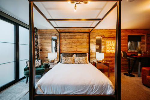 Luxury canopy bed in Cherry Tree Suite at Shrewsbury Rooms, featuring wooden walls, neon sign, and modern amenities