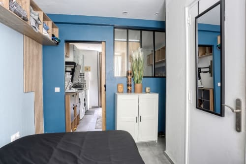 Suite moderne au Queen And King hotel de Versailles avec murs bleus, kitchenette et vue sur le jardin