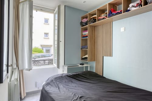 Chambre moderne à l'hôtel Queen And King à Versailles avec armoire intégrée en bois, mur d'accent bleu et balcon à la française
