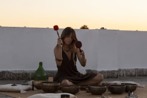 Donna che suona le campane tibetane a Villa Ceci B&B ad Andria, Italia, esperienza di benessere e meditazione