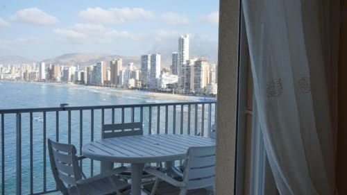 Vista del balcón de Portofino Playa Apartamentos con mesa, sillas y horizonte de playa de Benidorm
