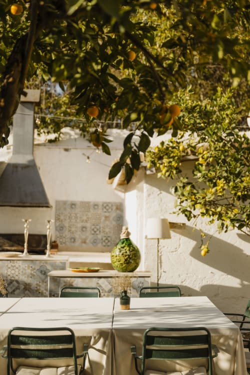 Zona pranzo nel cortile di Villa Ceci ad Andria con limone, muri bianchi e atmosfera mediterranea