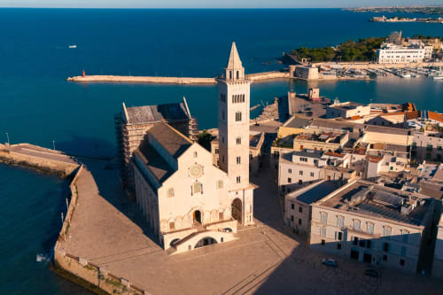 Vista aerea della bianca chiesa con campanile che domina il turchese mare Adriatico ad Andria, Italia, vicino a Villa Ceci