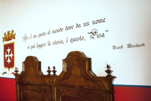 Elegante testiera in legno lavorato nella Triple Room di Agriturismo Villa Mocenigo, Mirano, con decorazioni araldiche alle pareti