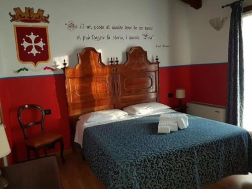 Camera tripla all'Agriturismo Villa Mocenigo di Mirano con letto in legno, pareti rosse e arredamento d'epoca