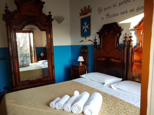 Camera tripla a Agriturismo Villa Mocenigo a Mirano con arredamenti antichi, pareti blu e biancheria bianca