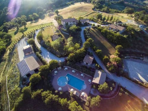 Aerial view of Agriturismo Colle Mura villa in Gualdo Tadino with pool, countryside, and river