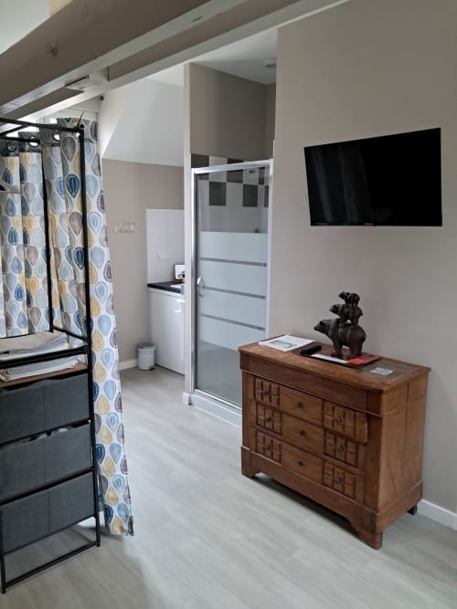Spacieuse chambre familiale au Domaine De Bertheauville avec commode en bois, TV écran plat et salle de bain privative