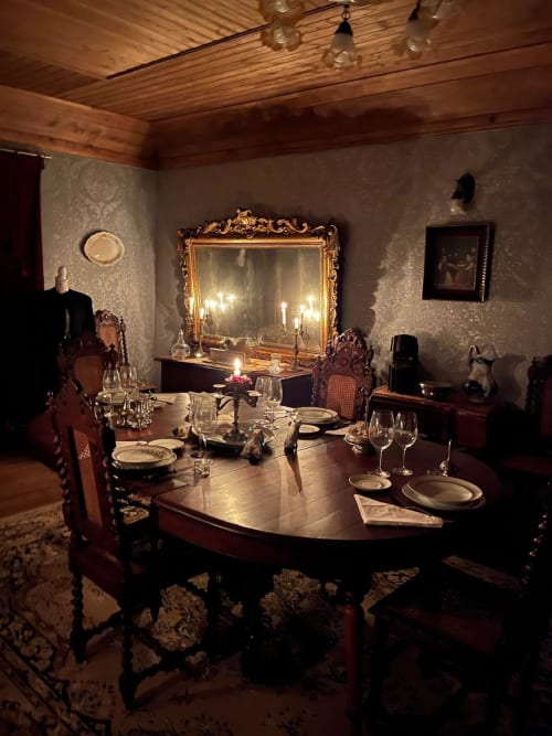 Elegant dining room at Quinta das Pias with ornate mirror, candlelit table settings, and traditional Portuguese decor