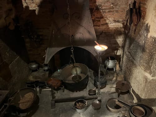 Historic kitchen setup at Quinta das Pias with traditional cooking hearth, cast iron pots, and rustic Portuguese countryside