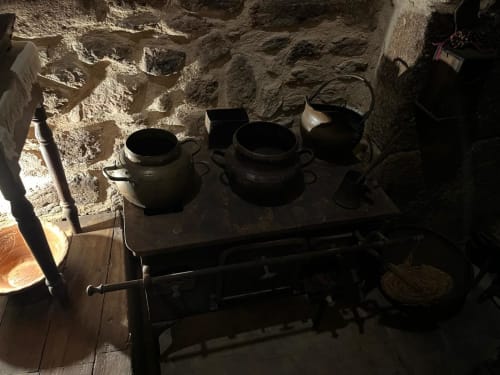 Traditional cast iron cookware and stove at Risoturismo Portuguese quinta, displaying rustic heritage hospitality experience