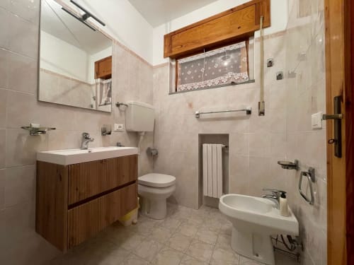 Bagno moderno nell'appartamento LHE Alba di Cesena con vanità in legno, bidet, doccia e scaldasalviette