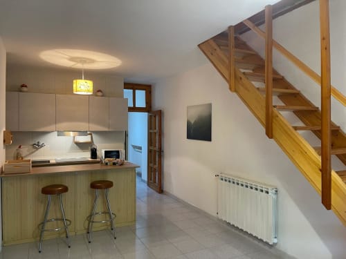 Moderna cucina in appartamento con scala in legno, zona bar e vista sulle montagne a Cesena, Italia