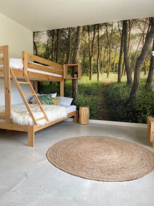 Cama literas de madera en dormitorio con temática forestal en Entheos Rural, Lerín, con luz natural y alfombra redonda de yute