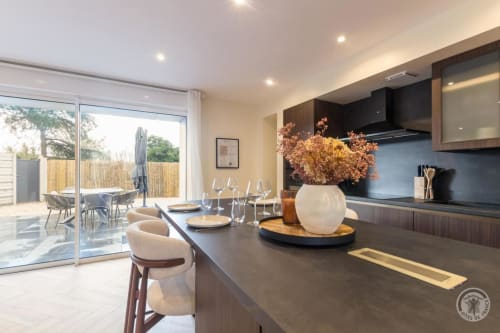 Modern cottage kitchen at La Bergerie De Montitier with garden view, black countertops, and dining area