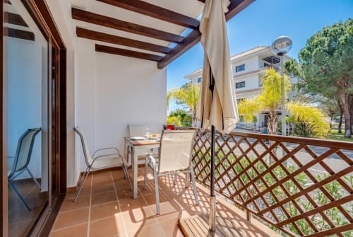 Terraço ensolarado do apartamento Pine Sun 29 em Silves com mesa de jantar, espreguiçadeiras e vistas para o jardim