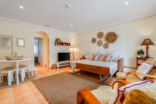 Estúdio iluminado em AlgarStays em Silves com cama de madeira, área de estar, mesa de jantar e decoração em vime